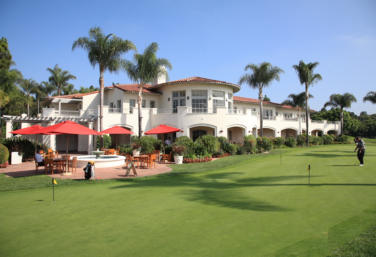 Aviara golf clubhouse with palms and a putting green